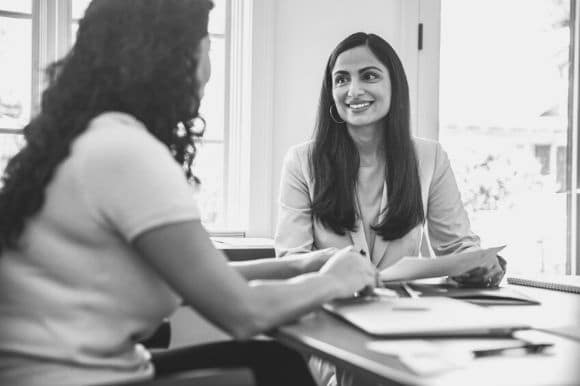 Accounts receivable manager talking with co-worker in office