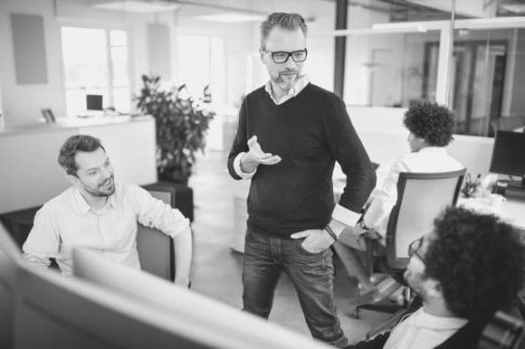 Assistant office manager talking with co-workers in an office