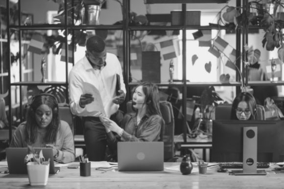 Call center supervisor helping an employee at work