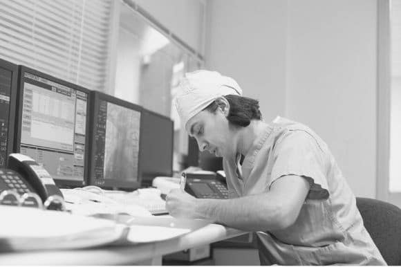 Cardiology technician taking notes in an office