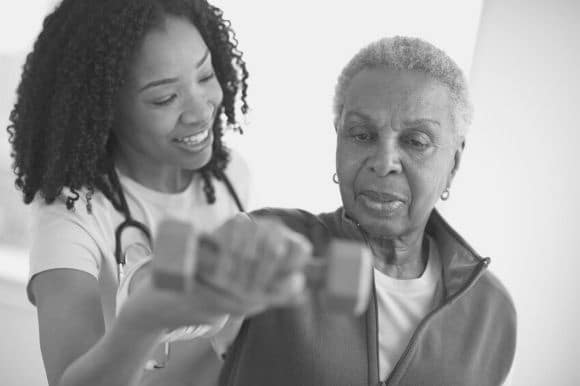 Chief physical therapist helping a patient with exercises