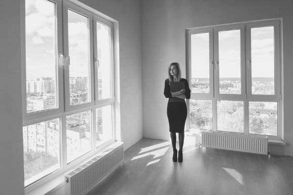 An estimator, standing in an empty high rise condo, assessing its value.