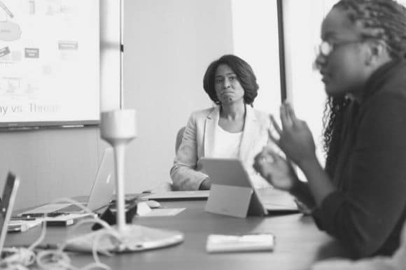 Finance director listening to a colleague during a team meeting.