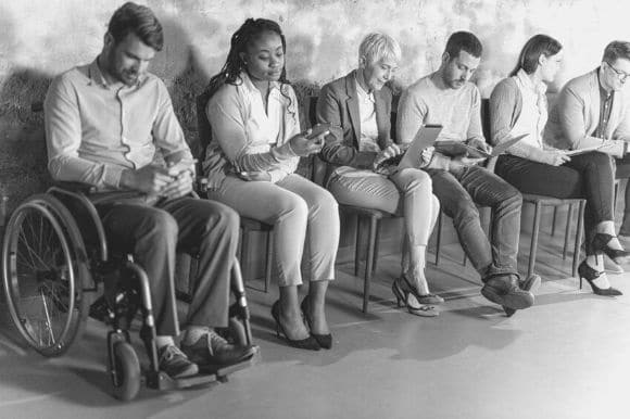 A diverse pool of job candidates waiting for their interviews.