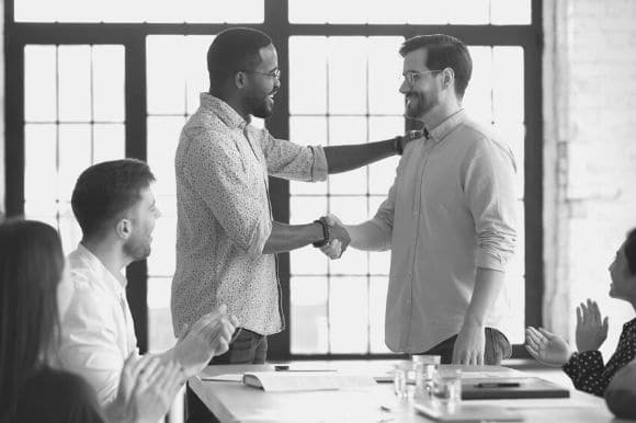 A hiring manager shakes the hand of a new employee he just hired.