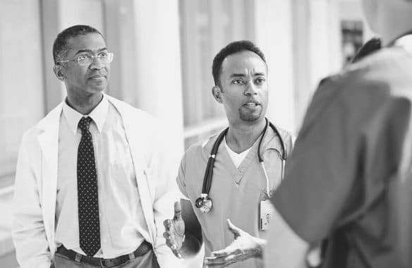 A charge nurse meets with his team. You can use this charge nurse job description template to hire a leader.