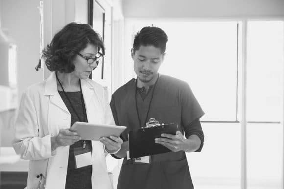 A doctor works with a nursing assistant in a hospital.