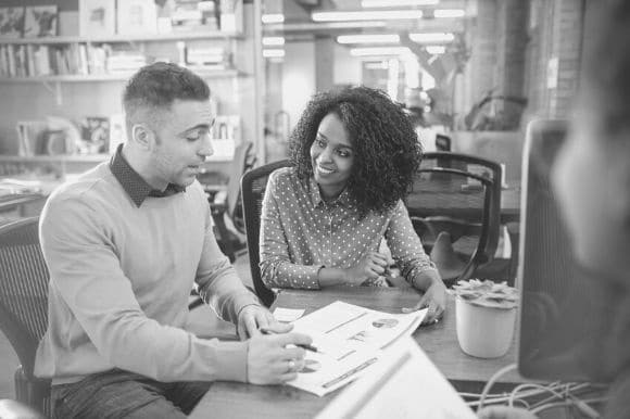 A sales and marketing manager going over some numbers with one of his salespeople.