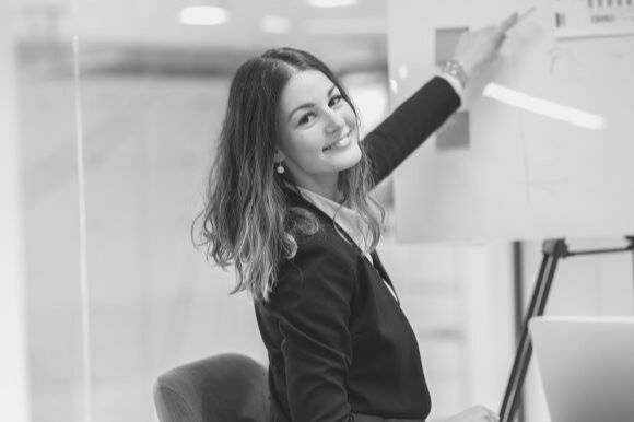 Sales trainer pointing to display board in conference room