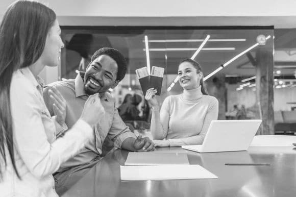 A travel agent showing her clients two plane tickets.