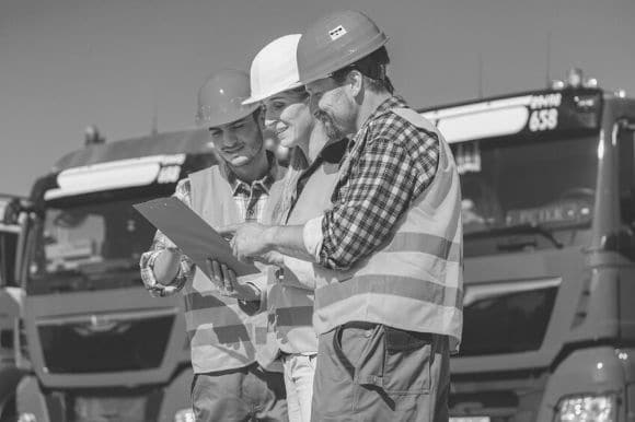 A truck dispatcher discussing routes with two of her drivers.