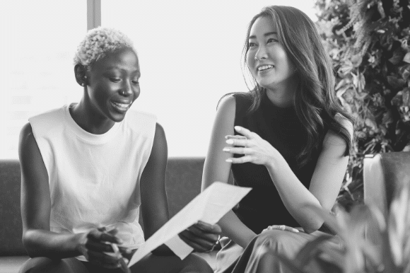 Two women, hiring managers, review possible company job titles for use in their recruitment efforts.