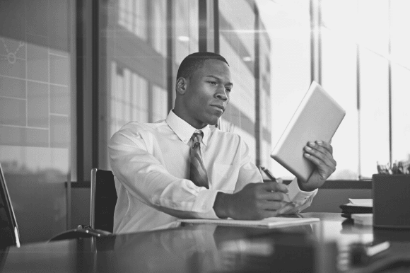 Contract manager sitting at desk and reviewing documents.