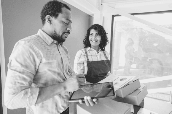 Mail clerk delivering packages to an employee, is signing for it on a tablet.